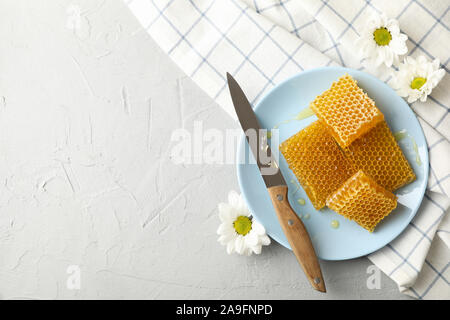 Platte mit Waben und Messer auf weißem Hintergrund, Ansicht von oben Stockfoto