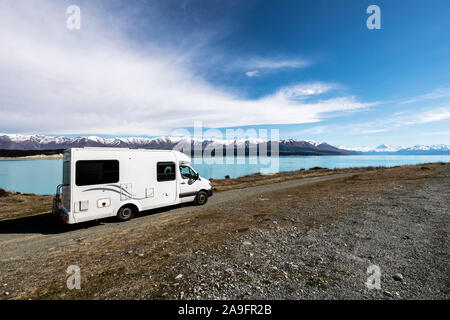 Reisemobil in Feldweg mit blauen See und Schnee caped Berge Stockfoto