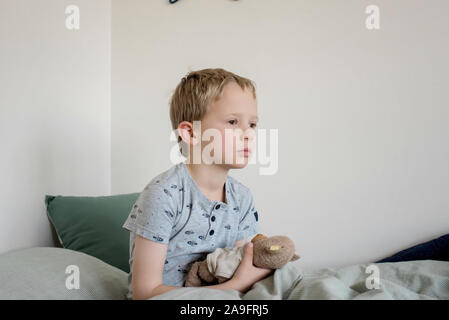 Junge in seinem Bett Aufwachen am Morgen zu Hause Stockfoto