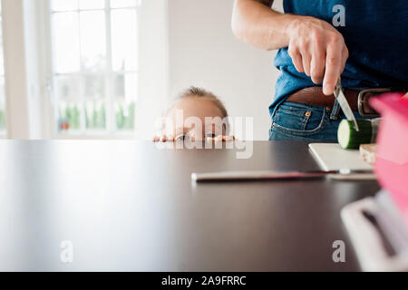 Vater, ein Lunchpaket für die Schule, während seine Tochter Uhren Stockfoto