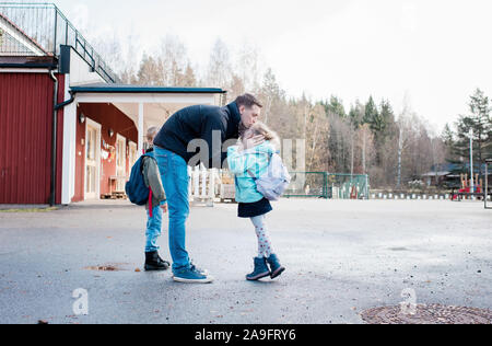 Vater Abschied von seinen Kindern an der Schule gate Stockfoto
