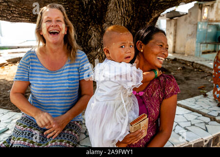 Eine burmesische Kind ist beim Anblick einer Kaukasischen weibliche Touristen die Kuthodaw Pagode, Mandalay, Myanmar erschrocken. Stockfoto