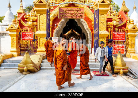 Eine Gruppe von buddhistischen Mönchen am Eingang der Kuthodaw Pagode, Mandalay, Myanmar. Stockfoto