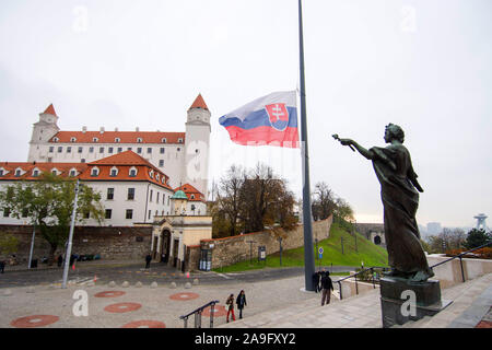 Slowakische Flagge zum halben Personal fliegen auf der Alexander Dubcek Square in Bratislava, Slowakei, am Freitag, 15. November 2019. Die Slowakei hat ein Tag der Trauer für die Opfer der Mittwoch Absturz eines Lkw zu gedenken und ein Bus in der Nähe von Nitra, in der Slowakei, in denen 12 Menschen starben, darunter fünf Kinder, und rund 20 wurden verletzt. Im Hintergrund ist die Burg von Bratislava zu sehen. (CTK Photo/Martin Mikula) Stockfoto