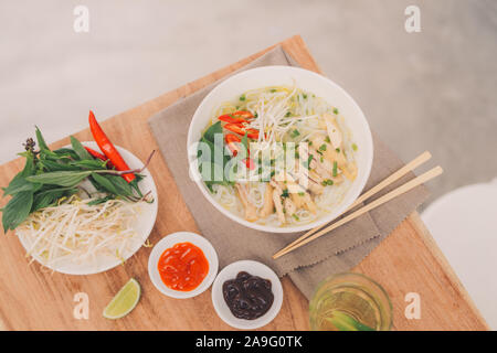 Traditionelle vietnamesische Nudelsuppe pho in Schalen, konkreten Hintergrund. Vietnamesische Rindfleisch Suppe pho bo, Close-up. Asiatische und vietnamesische Küche. Vietnamesische Abendessen Stockfoto