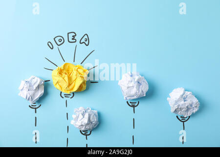 Glühbirne und Papier Kugeln auf blauem Hintergrund, Platz für Text Stockfoto