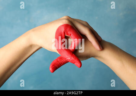 Zwei Hände zeigen AIDS Awareness Zeichen gegen den blauen Hintergrund, in der Nähe Stockfoto