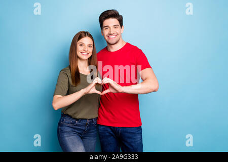 Portrait von positiven zwei Ehegatten zeigen Herz Form Hände leidenschaftliche Liebe Symbol feiern Valentinstag Urlaub tragen grüne modern t-shirt denim Outfit Stockfoto