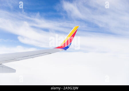 Auf der Suche einer südwestlichen Flugzeug Fenster im Flug den Flügel, blauer Himmel und Wolken. Stockfoto