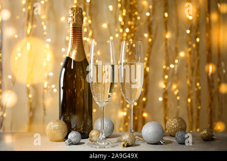 Christbaumkugeln, Champagner Gläser und Flaschen gegen eingerichtet. Bokeh effect Stockfoto