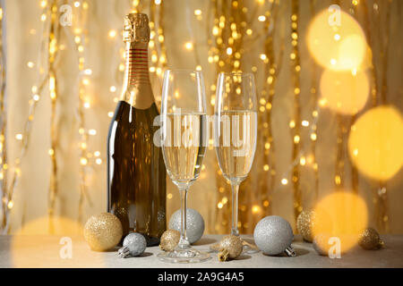 Christbaumkugeln, Champagner Gläser und Flaschen gegen eingerichtet. Bokeh effect Stockfoto