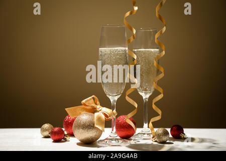 Kugeln und Champagner Gläser gegen goldenen Hintergrund, Platz für Text Stockfoto