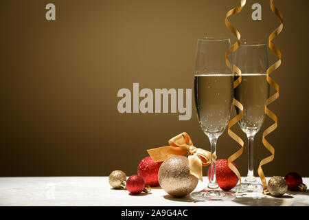 Kugeln und Champagner Gläser gegen goldenen Hintergrund, Platz für Text Stockfoto