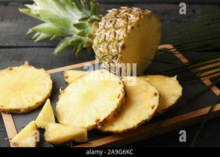 Schneidbrett mit Ananas und palm leaf auf hölzernen Hintergrund, in der Nähe Stockfoto