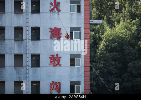 Kunming, Provinz Yunnan in China. 15 Nov, 2019. Ein Feuerwehrmann zeigt rescue Skill während einer Räumungsübung in Kunming, der Hauptstadt der Provinz Yunnan im Südwesten Chinas, Nov. 15, 2019. Credit: Hu Chao/Xinhua/Alamy leben Nachrichten Stockfoto