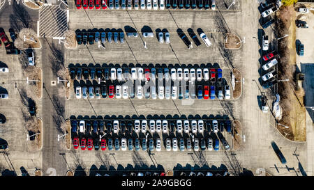 Eine Antenne/drone Ansicht einer Autohaus und Parkplatz mit Autos aufgereiht nebeneinander. Stockfoto