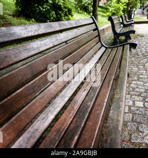 Tau Bänke. Eine konventionelle Parkbank Einstellung in einem städtischen Park. Hamburg, Deutschland. Stockfoto