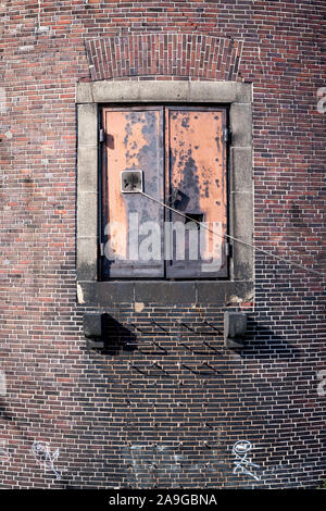 Lager Heckklappe. Eine stählerne Tür auf der Seite einer alten gewölbten Waterfront Warehouse ermöglicht den Zugang zu Schiffen. Stockfoto