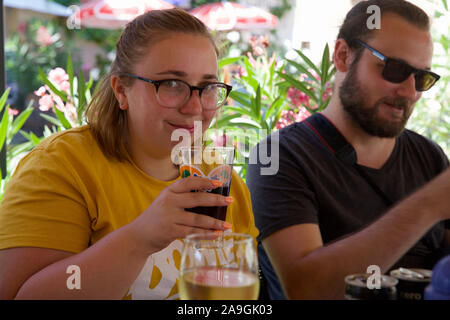 Junges Paar Alkoholkonsum außerhalb auf Urlaub. Stockfoto