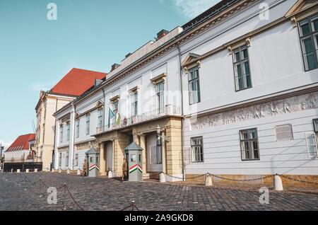 Budapest, Ungarn - Nov 6, 2019: Ungarische Präsidentenpalast, Sandor Palace. Ehrengarde in Uniform vor dem Gebäude. Flaggen der EU und Ungarn. Bewaffnete Soldaten auf eine Pflicht. Stockfoto