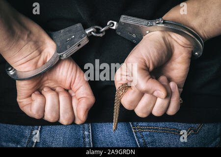 Festgenommene Mann auf den Diebstahl von Gold in einem Store gefangen. In Handschellen die Hände closeup Stockfoto