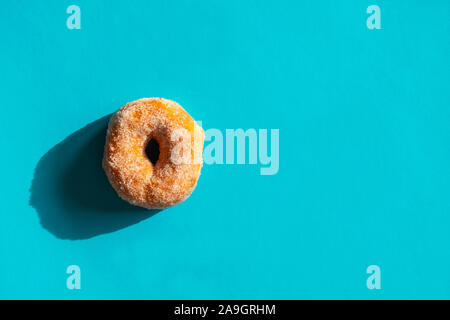 Klassische fried gezuckerte Donut auf hellen blauen Hintergrund Stockfoto