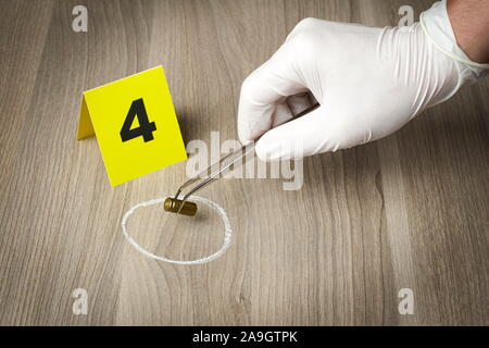 Forensic officer Sammeln einer bullet Gehäuse als Beweisstück Stockfoto