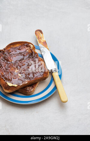 Marmite auf Toast auf einem Teller auf weißem Hintergrund Stockfoto