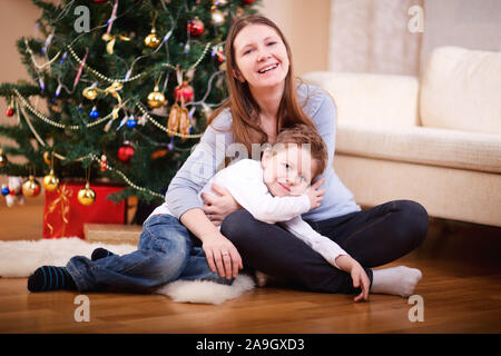 Finnland, Lets, Mutter und Kleinkind vor Weihnachtsbaum Stockfoto