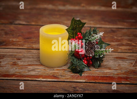 Winterurlaub Weihnachten noch leben Der leuchtende elektrische Kerze und Holly Berry Blumenschmuck Stockfoto