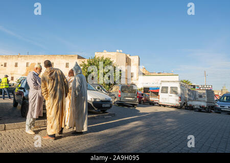 Fez, Marokko. November 9, 2019. Drei Männer in traditioneller Kleidung sprechen auf einer Straße Stockfoto