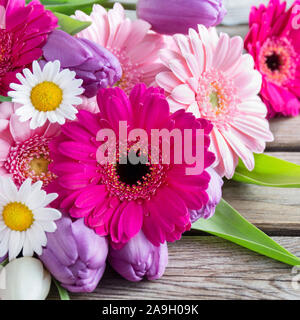 Blumenstrauß gegen Holzbrett Stockfoto