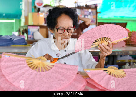 Ältere Frau, handgeschöpftem Papier Ventilatoren an Bo Sang weiter nach Chiang Mai, Thailand Stockfoto