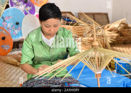 Thailändische Frau, handgeschöpftem Papier Sonnenschirme am Bo Sang weiter nach Chiang Mai, Thailand Stockfoto