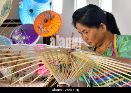 Thailändische Frau, handgeschöpftem Papier Sonnenschirme am Bo Sang weiter nach Chiang Mai, Thailand Stockfoto