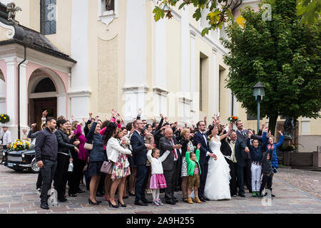 Hochzeitsfeier wave zusammen für die offiziellen Fotografen außerhalb der Pfarrkirche St. Ulrich (San Ulrico) in St. Ulrich Stockfoto