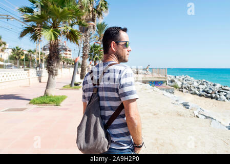 Mann, der an der Promenade mit Blick auf Horizont, an einem sonnigen Tag Stockfoto