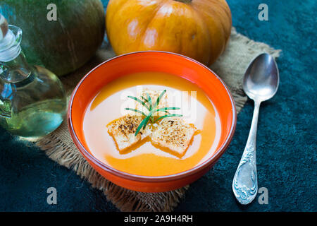 Kürbispüree Suppe mit Knoblauch croutons auf einem Schwarzen Tisch. Ansicht von oben. Stockfoto