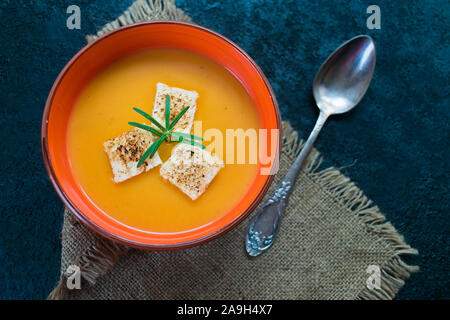 Kürbispüree Suppe mit Knoblauch croutons auf einem Schwarzen Tisch. Ansicht von oben. Stockfoto