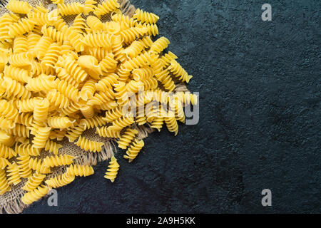 Rohe Nudeln auf einem schwarzen Hintergrund. Kopieren Sie Platz. Stockfoto