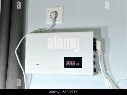 Kompakte Wand Automatischer Spannungsregler (AVR) für Gas Boiler zu schützen. Manometer im Kesselraum in der Nähe der Heizrohre mit Isolierung Beschichtung. Stockfoto