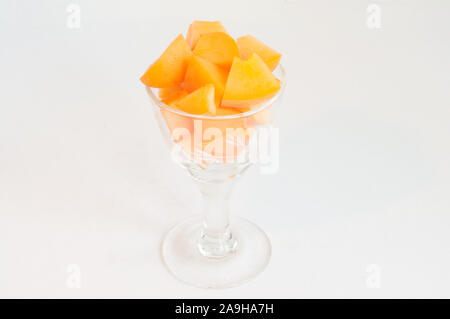 In der Nähe von frischem Orange Frucht, in einem schönen kleinen Glas, weißem Hintergrund; Stockfoto