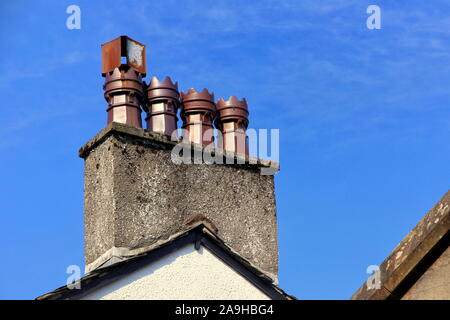 Zeile vier alten verzierten Keramik Schornstein Töpfe auf dem Dach Schornstein, mit blauem Himmel Stockfoto