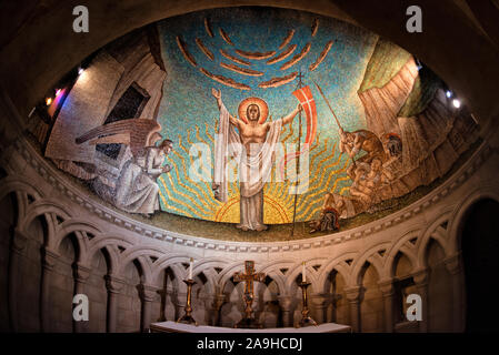 WASHINGTON, DC -- ein Apsismosaik von Philip Frohman namens Resurrection (1951) in der Resurrection Chapel in der National Cathedral in Washington DC. Das Mosaik besteht aus kleinen farbigen Glasfliesen und wurde von Ravenna-Mosaiken ausgeführt. Die Kapelle der Auferstehung ist eine der Kapellen in der Krypta unter der Nationalkathedrale. Die Washington National Cathedral ist eine episkopale Kirche in Washington DC und ist der Standort vieler prominenter Kirchen- und Gedenkstätten von Washington DC. Der im neugotischen Stil gestaltete Bau wurde 1906 begonnen, wobei die Arbeiten fortgesetzt wurden Stockfoto