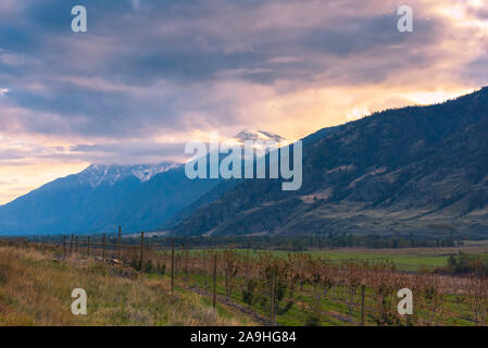 Blick von crowsnest Highway von Herbst Tal mit Blick auf die schneebedeckten Berge und dramatische Wolken bei Sonnenuntergang im Cawston, BC, Kanada Stockfoto