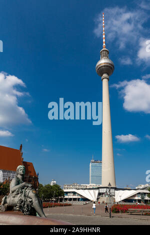 Berlin Deutschland - Juni 2019: Ansicht von unten auf das Berliner Fernsehturm (Fernsehturm) Unter blauem Himmel mit Lady Skulptur im Vordergrund. Stockfoto