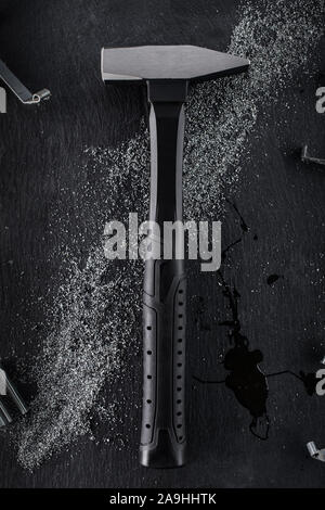 Professionelle black Hammer aus verstärktem Stahl auf einem dunklen Stein Hintergrund platziert. Die Aussicht von oben. Stockfoto