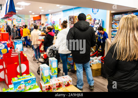 Die Menschen warten geduldig inline für ihr Spielzeug an der Entertainer in der intu Potteries Shopping Centre, Christmas shopping, Xmas Warteschlangen Stockfoto