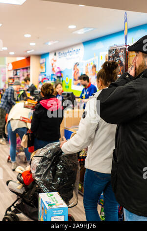 Die Menschen warten geduldig inline für ihr Spielzeug an der Entertainer in der intu Potteries Shopping Centre, Christmas shopping, Xmas Warteschlangen Stockfoto