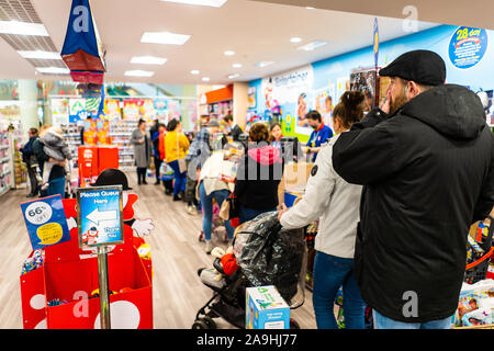 Die Menschen warten geduldig inline für ihr Spielzeug an der Entertainer in der intu Potteries Shopping Centre, Christmas shopping, Xmas Warteschlangen Stockfoto